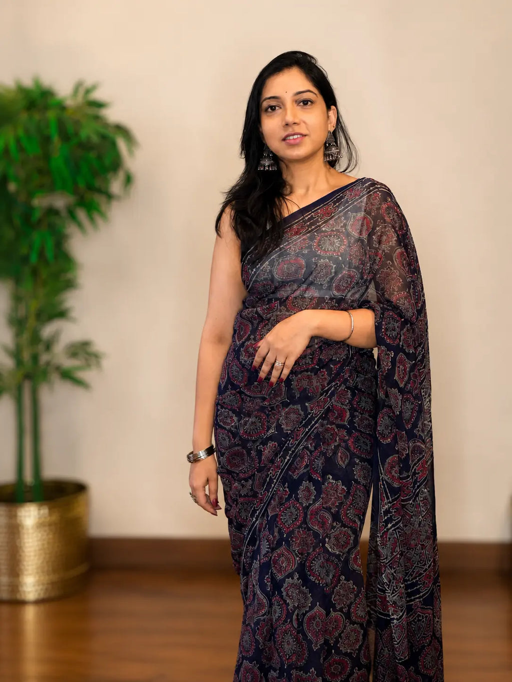 Woman wearing Tiulip Midnight Mist black chiffon saree with elegant drape and lightweight flowing fabric