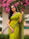 Woman wearing green handwoven cotton Jamdani saree with traditional motifs