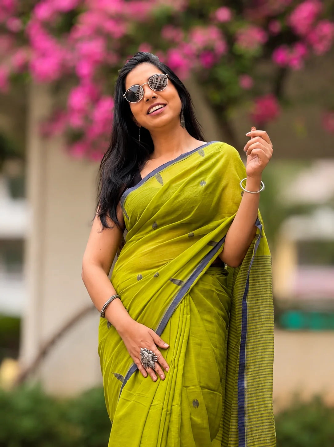 Woman wearing green handwoven cotton Jamdani saree with traditional motifs