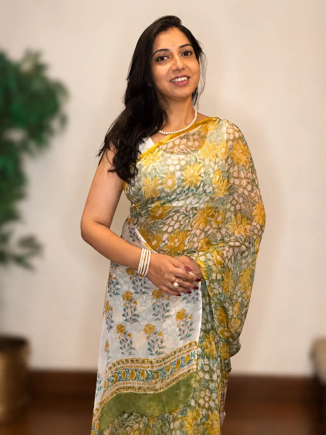Woman wearing Tiulip Sunlit Petals white floral chiffon saree with yellow floral prints and graceful flowing drape