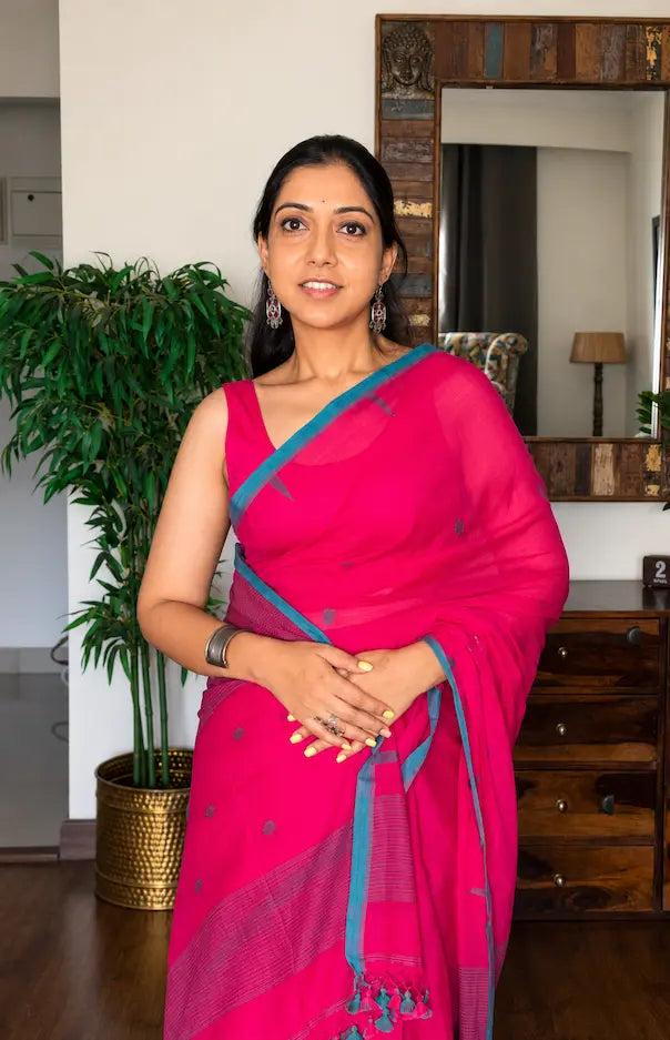 Woman wearing pink handwoven cotton Jamdani saree with traditional motifs