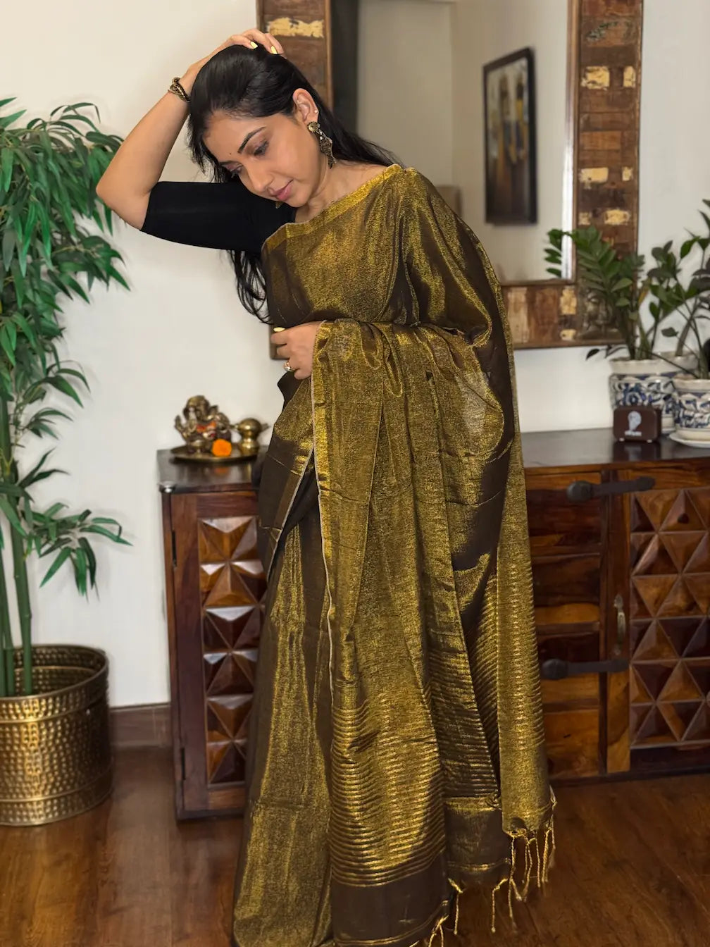 Women wearing Golden zari border detail on handwoven tissue saree Full drape