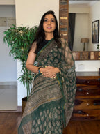 Woman wearing green handwoven Kota Doria saree with traditional woven design