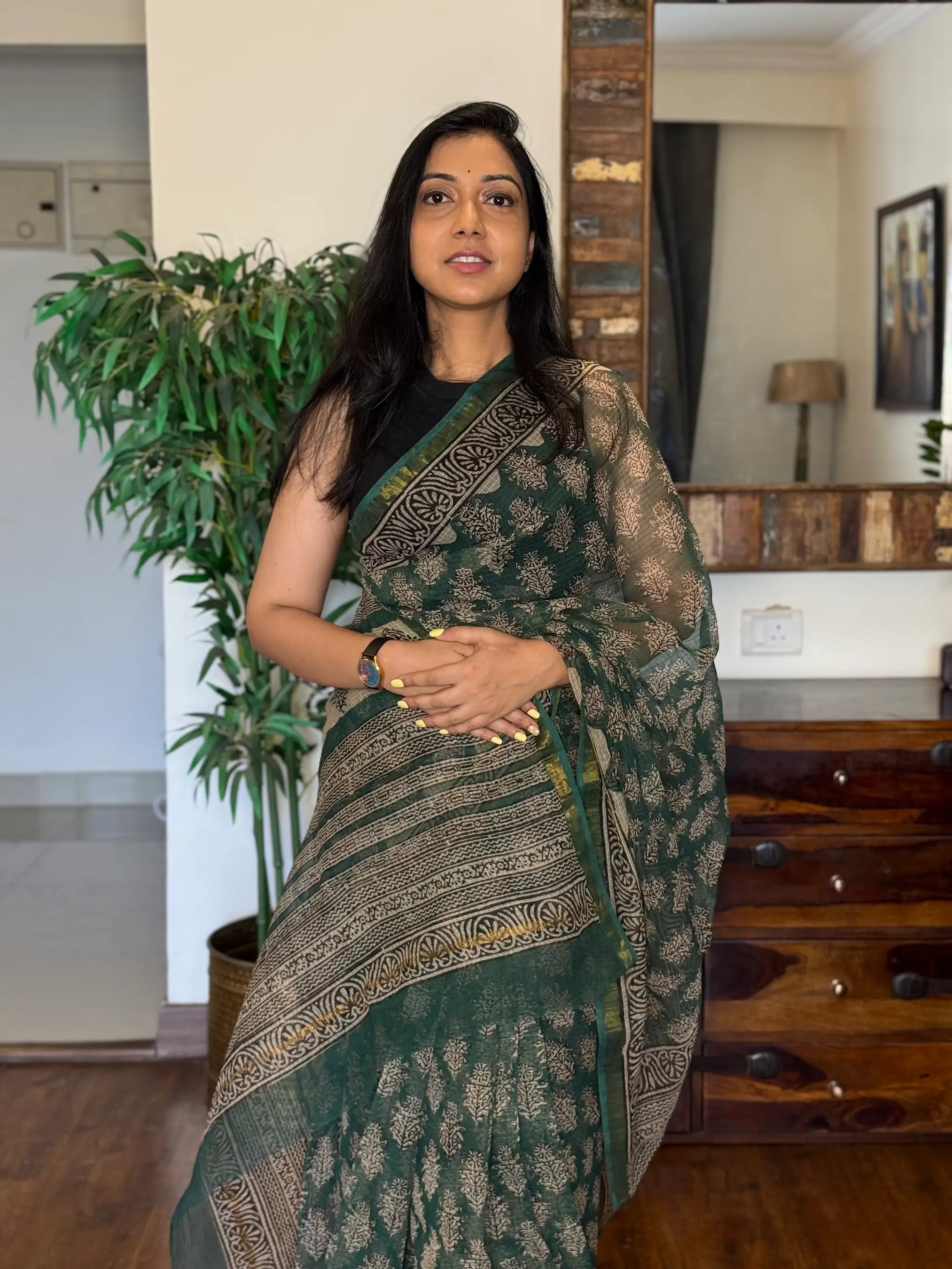 Woman wearing green handwoven Kota Doria saree with traditional woven design