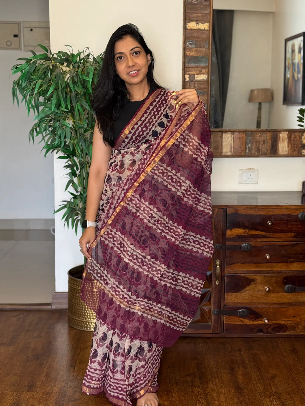 Woman wearing red handwoven Kota Doria saree with traditional woven design