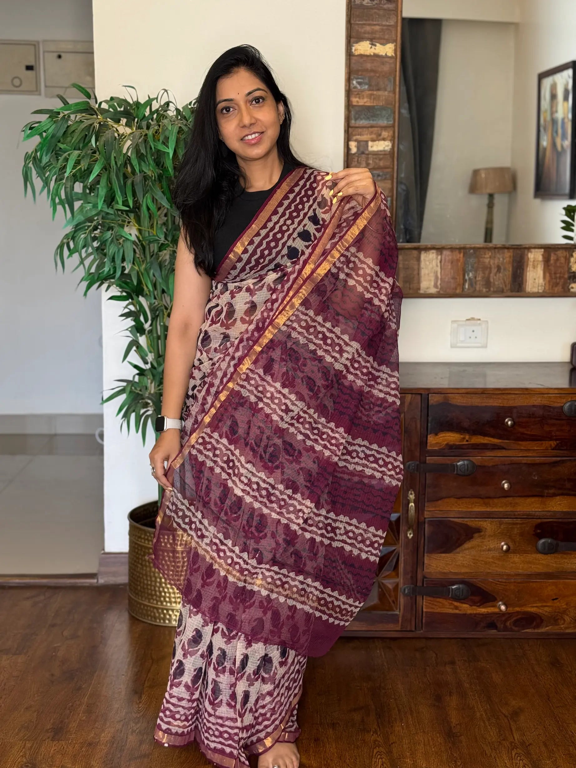 Woman wearing red handwoven Kota Doria saree with traditional woven design