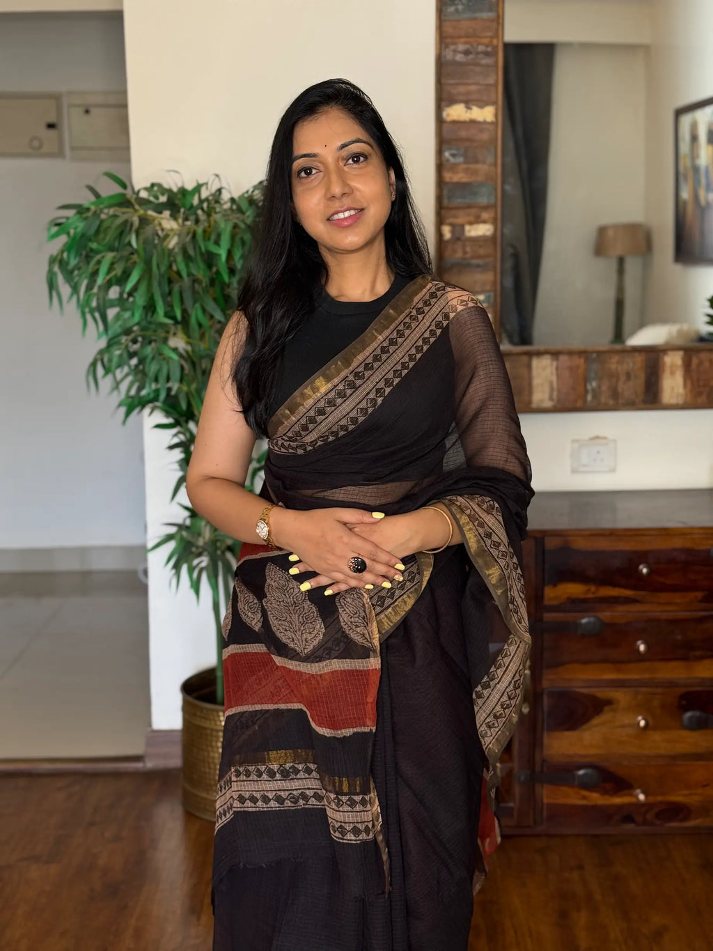 Woman wearing black handwoven Kota Doria saree with traditional woven design