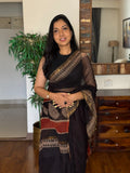 Woman wearing black handwoven Kota Doria saree with traditional woven design