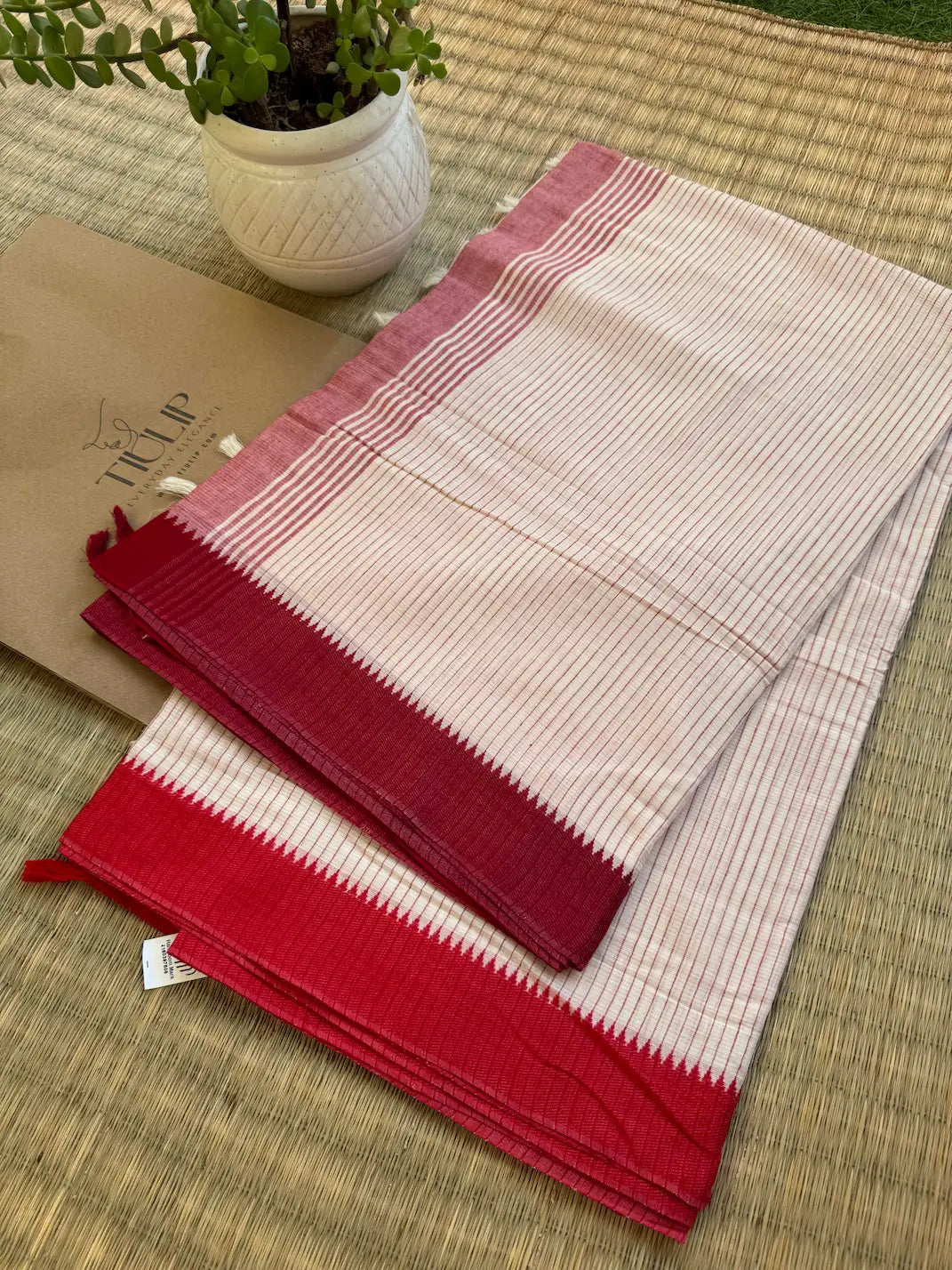 Sharmistha pure handwoven white Dhaniakhali cotton saree with fine vertical woven lines and a classic red border for office wear, festive mornings, and everyday elegance