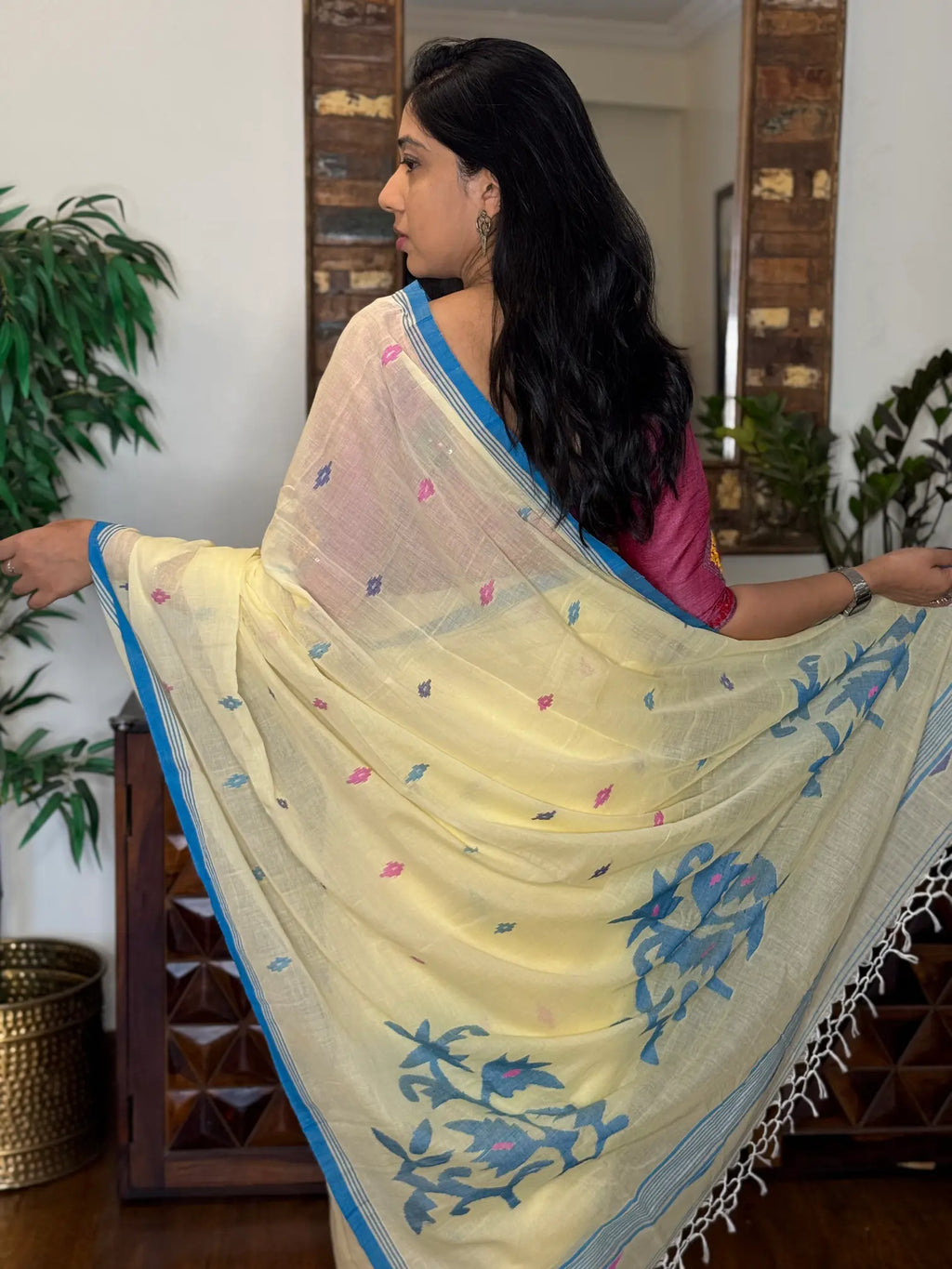 Woman wearing white handwoven cotton Jamdani saree with traditional motifs