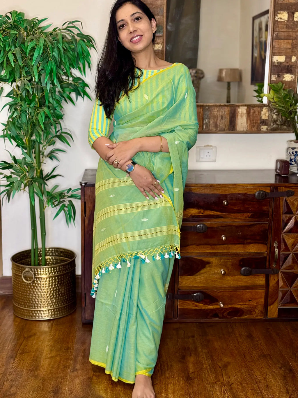Woman wearing light green handwoven cotton Jamdani saree with traditional motifs