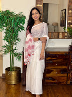 Woman wearing white handwoven cotton Jamdani saree with traditional motifs
